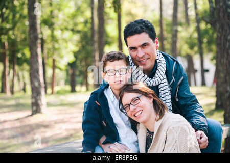 Portrait of happy family sitting on in forest