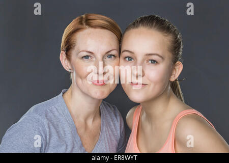 Portrait of smiling mother and daughter against gray background Stock Photo