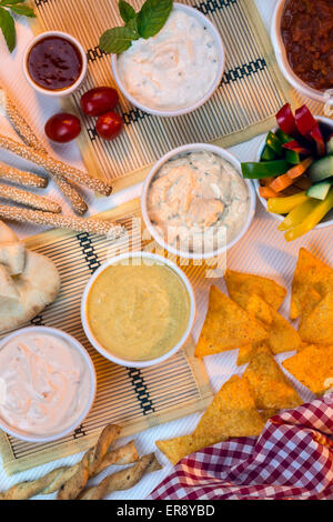 A selection of party dips with bread sticks, pita bread and other crudites. Stock Photo
