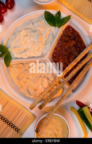 A selection of party dips with bread sticks and other crudites. Stock Photo