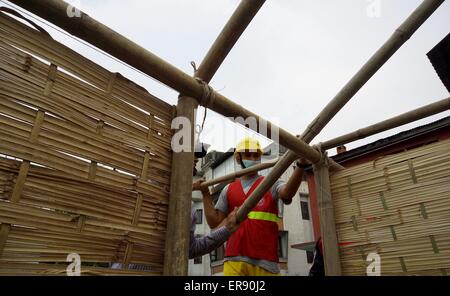 Kathmandu, Nepal. 29th May, 2015. A volunteer works to build temporary classrooms outside a damaged school in Kathmandu, capital of Nepal, on May 29, 2015. Schools in quake-affected districts are making further preparations to resume classes scheduled on May 31. Credit:  Sunil Sharma/Xinhua/Alamy Live News Stock Photo