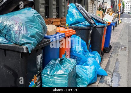 Rubbish bags and garbage containers with piled up household refuse blocking pavement due to strike by the waste processing firm Stock Photo