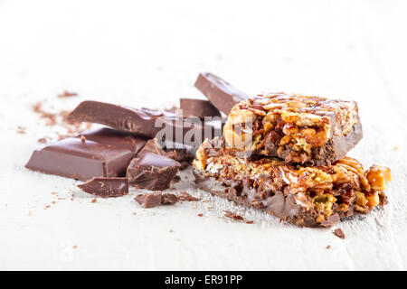 granola bar with chocolate on white wooden background Stock Photo