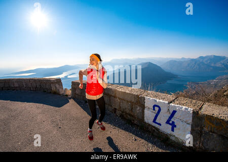 Woman running on the mountain road Stock Photo