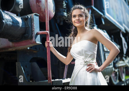 Portrait of happy wedding bride near the old steam locomotiv Stock Photo