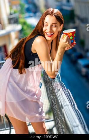 Woman with colorful coffee cup on the balcony Stock Photo