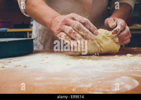Closeup photo of baker making yeast dough for bread. Retro styled imagery Stock Photo