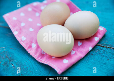 Eggs on tablecloth over wooden background Stock Photo