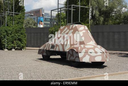 Sunny view camouflage painted replica Kubus Armoured Car in front of Home Army insurgents Memorial Wall, Warsaw Uprising Museum Stock Photo