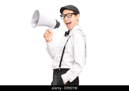Young artistic man speaking on a megaphone and leaning against a wall isolated on white background Stock Photo