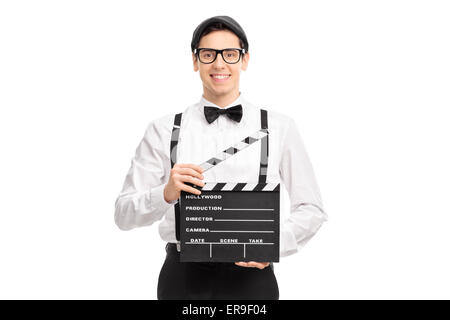 Young movie director holding a movie clapperboard, smiling and looking at the camera isolated on white background Stock Photo