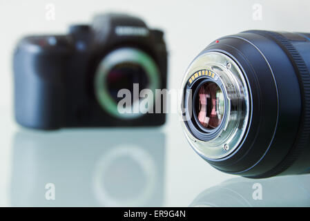 Still life of dslr camera and photo lens on glass table. Closeup of electronic circuit, rear glass and mount with copyspace in f Stock Photo