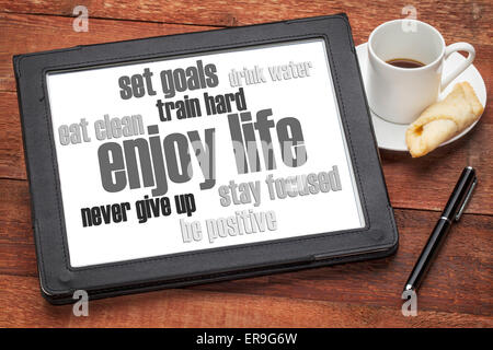 enjoy life - healthy lifestyle word cloud on a digital tablet with a cup of coffee Stock Photo