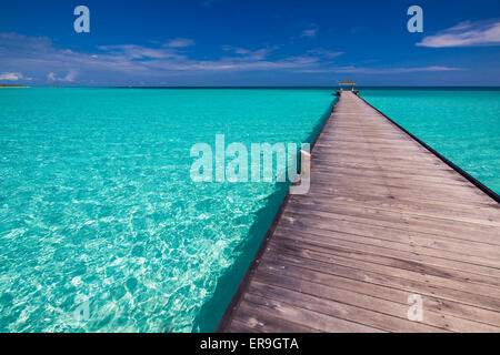 Wooden long jetty over lagoon in Maldives with amazing clean water ...