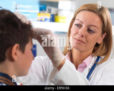 PROPERTY RELEASED. MODEL RELEASED. Doctor cleaning head wound in a accident clinic. Stock Photo