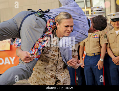 US Marine 1st Lt. Monica Witt carries MSNBC news anchor Thomas Roberts during the morning talk show Today as a part of Fleet Week May 23, 2015 in New York City, NY.  Marines showcase the capabilities of the Marine Corps both physically, mentally and technologically during Fleet Week New York. Stock Photo