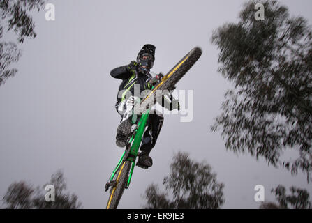 Mountain biker on a downhill course jumping through the air - motion blur Stock Photo