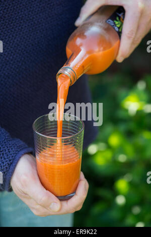 Pouring carrot juice into a glass Stock Photo