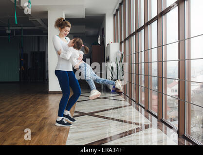 Mother twist her daughter in the gym Stock Photo