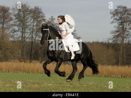 angel and friesian horse Stock Photo