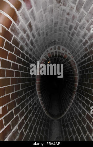 Portrait shot red tiles replica oval sewer canal, as those used by insurgents in World War 2, Warsaw Uprising Museum, Poland Stock Photo