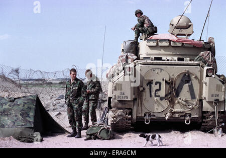 25th March 1991 U.S. Army soldiers relax next to their Bradley Cavalry Fighting Vehicle, on the border in northern Kuwait.