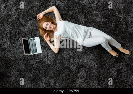 Young woman laying on the carpet Stock Photo