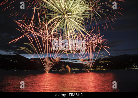 Lakefront Luino fireworks on the Maggiore lake in summer evening, Lombardy - Italy Stock Photo