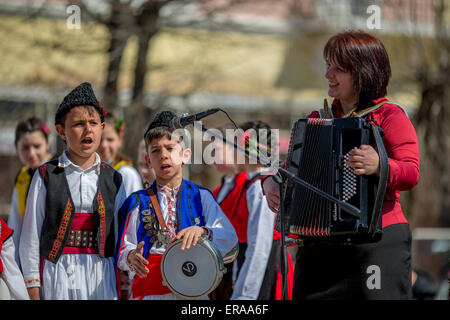 Young Bulgarian folklore singers performing a song with their music teacher during a traditional folklore festival Stock Photo