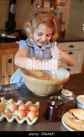 Pretty blond haired girl mixing ingredients in a bowl Stock Photo