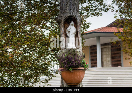 Statue of the Our Lady in hollow trunk the garden in front of the church dedicated to the Blessed Virgin Mary in the village of Santa Maria in Fabriago near Ravenna in the countryside of Emilia Romagna in Northern Italy. Stock Photo