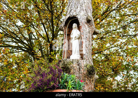 Statue of the Our Lady in hollow trunk the garden in front of the church dedicated to the Blessed Virgin Mary in the village of Santa Maria in Fabriago near Ravenna in the countryside of Emilia Romagna in Northern Italy. Stock Photo