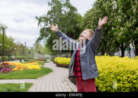 happy little boy in the red shirt with hands up. freedom concept. Stock Photo