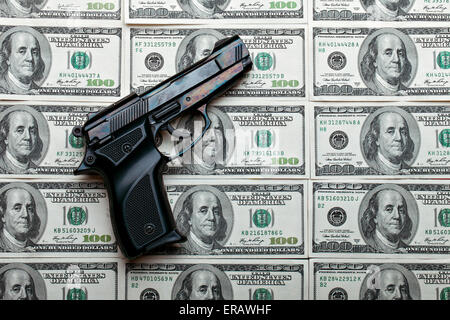 Money and weapons. Gun against the dollar bills. Stock Photo