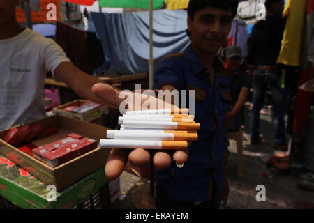 (150531) -- GAZA, May 31, 2015 (Xinhua) -- A Palestinian street vendor sells cigarettes in the southern Gaza Strip City of Rafah, on May 23, 2015. Smuggling through tunnels began several months after Islamic Hamas movement's control of the Gaza Strip and the Israeli blockade. This business flourished after the ouster of Egyptian President Hosni Mubarak in 2011, but declined since Egyptian President Mohamed Morsi was ousted and detained. Since then, 90 percent of the tunnels underneath the borders were destroyed, announced by Egyptian army and Hamas. A senior official in the Gaza ministry of fi