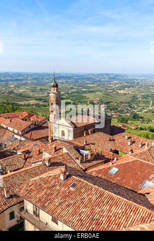 Church among red roofs in town of La Morra as green hills on background in Piedmont, Northern Italy (vertical composition). Stock Photo