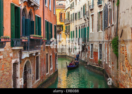 Gondola on small canal among old houses in Venice, Italy. Stock Photo