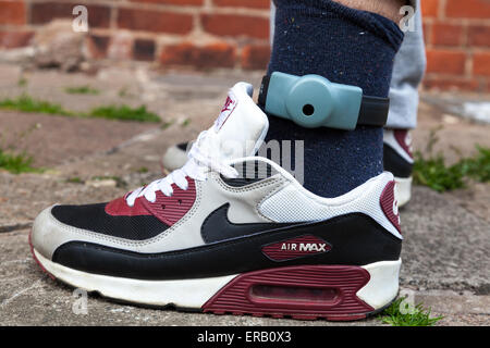 An electronic ankle tag on a teenage offender in the U.K. (identification number obscured). Stock Photo