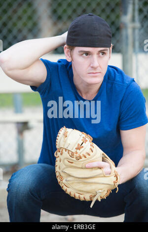 young man with baseball glove on a sports field Stock Photo