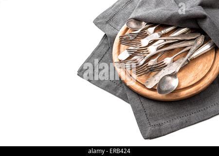 Antique silver cutlery on rustic wooden kitchen desk isolated on white background. Kitchen utensils Stock Photo