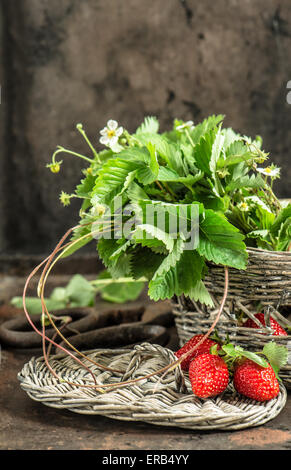 Fresh strawberries with leaves over wooden background with copy space ...