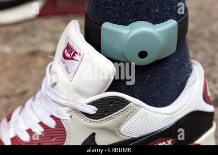 An electronic ankle tag on a teenage offender in the U.K. (identification number obscured). Stock Photo