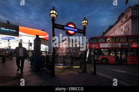 A man walks by a Tube entrance near a double-decker bus in Piccadilly Circus, in London, England, 2015. (Adrien Veczan) Stock Photo