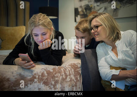 Family members enjoying a tablet and smart phone Stock Photo