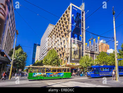 Iconic heritage green and yellow tram and bright blue modern tram in the business district of Melbourne's city centre, Australia Stock Photo