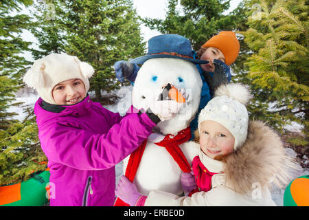Close-up of happy children build cheerful snowman Stock Photo
