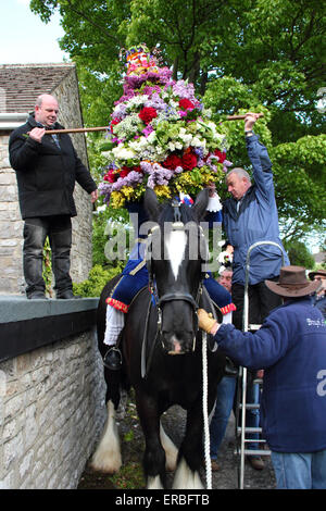 A floral headdress is placed on the Garland King to celebrate of Oak Apple Day in Castleton, Peak District, Derbyshire, UK Stock Photo