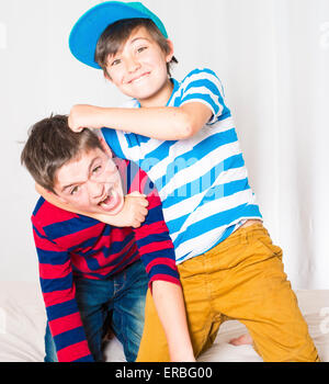 two young boys in bed and fighting Stock Photo