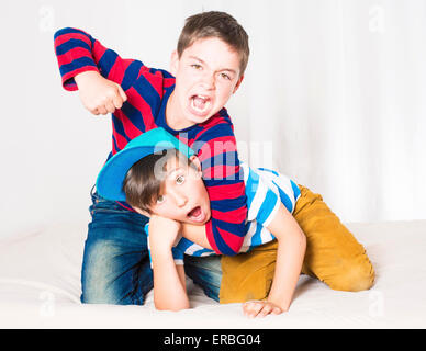 two young boys in bed and fighting Stock Photo