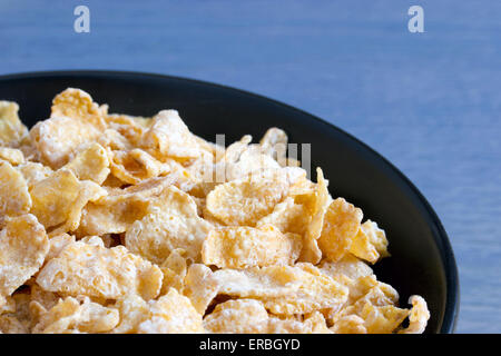 Black bowl with frosted cereal flakes Stock Photo